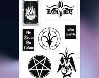 May include: A sheet of black and white stickers featuring occult symbols and text. Designs include a Baphomet illustration, a pentagram, and the phrases "As Above So Below" and "Solve Coagula". The stickers are on a white background.