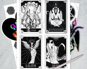 May include: A sheet of four black and white tarot cards featuring illustrations of Lucifer, Baphomet, Lilith, and Death. The cards are surrounded by stickers and a pen.