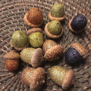 Set of 12 acorns glittered in fall colors.  Colors range from orange to various golds and brown.  Table decor or ornaments.