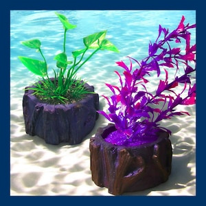 May include: Two artificial plants in decorative pots. The plant on the left has green leaves and is in a dark purple pot. The plant on the right has purple leaves and is in a brown pot.