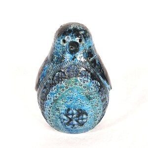 May include: A blue and black ceramic bird figurine with a textured surface and geometric patterns.