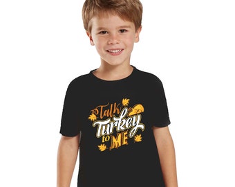 Puede incluir: Camiseta negra con un gráfico blanco que dice "Talk Turkey to Me" con un pavo y hojas de otoño en naranja y amarillo.