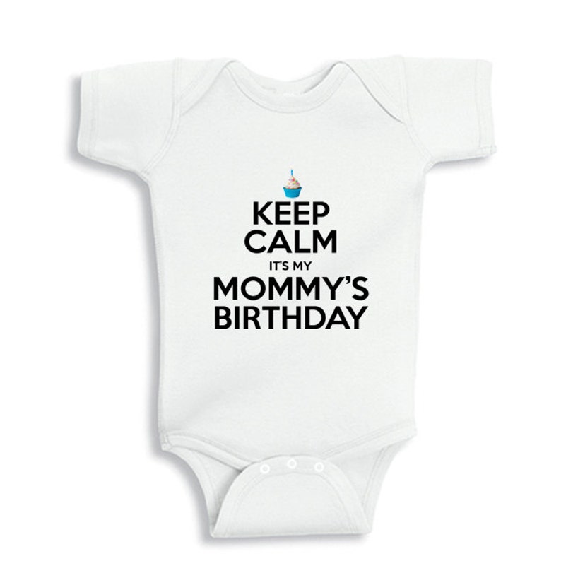 May include: White baby onesie with black text that reads "Keep Calm It's My Mommy's Birthday". A blue cupcake with a single candle is above the text.