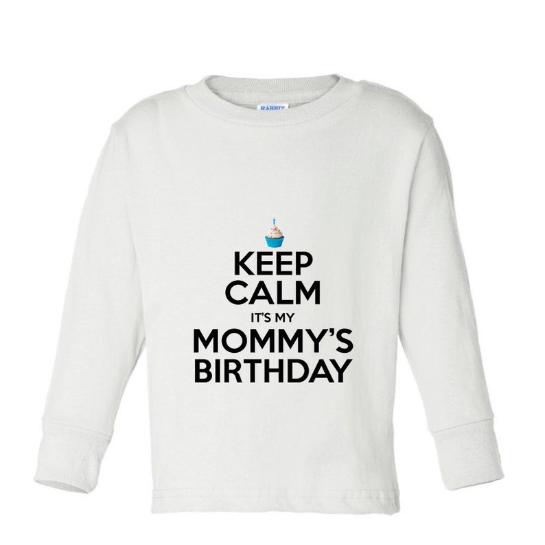 May include: White long-sleeve shirt with a black graphic that says "Keep Calm It's My Mommy's Birthday" with a blue cupcake icon.