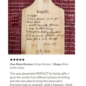 May include: A light-colored wooden cutting board shaped like a wine bottle, featuring a laser-engraved handwritten recipe for Jeanetta. The text includes ingredients like eggs, sugar, salt, Anisette, Crisco, baking powder, and flour, ending with io ti amo.