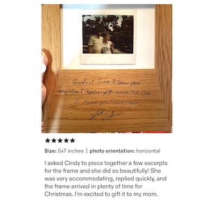 May include: A light-colored wooden picture frame featuring a square photo of two people at the top. The wood is engraved with the text: The first Time I saw you my Heart Knew you were The One, I love you SweetHeart, followed by a signature.