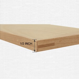 May include: A light brown wooden board with a smooth surface and a rectangular profile. The edge of the board features a horizontal slot running along its length. A measurement graphic indicates the thickness of the board is 1/2 inch.