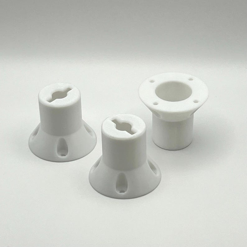 May include: Three white plastic parts with different shapes and sizes. The parts have a hole in the center and are designed to be used together.