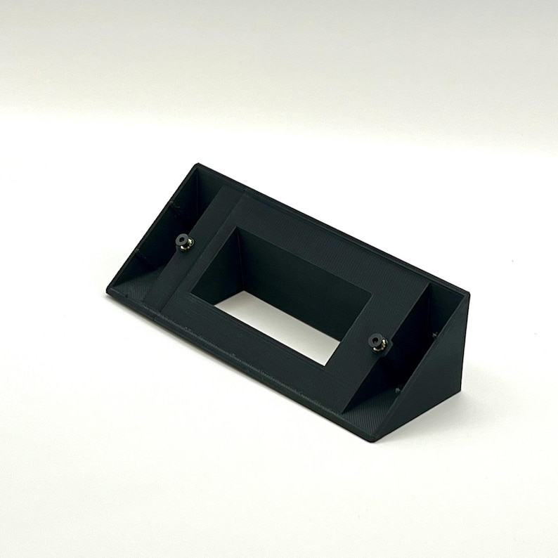 May include: Black plastic wall mount with a rectangular opening and two screw holes.
