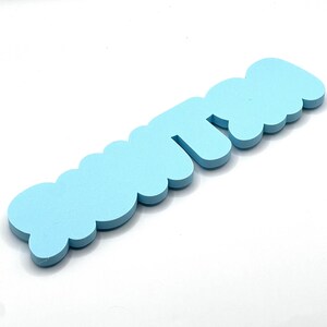 May include: Light blue foam letters spelling out the word "cutie".