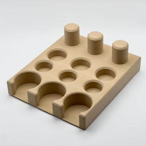 May include: A beige wooden organizer with 12 round compartments and 3 tall cylindrical slots. The organizer is designed to hold small items like essential oils or jewelry.