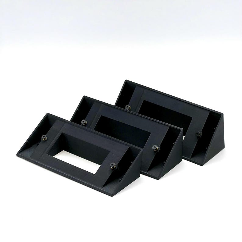 May include: Three black plastic wall mount brackets with a rectangular opening in the center. The brackets are angled and have small screw holes on the sides.