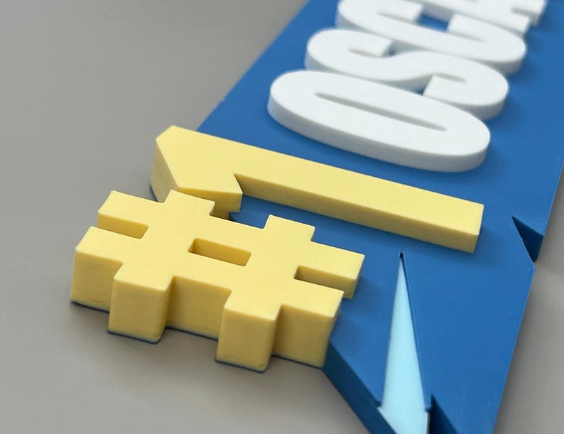 May include: A blue sign with white text and yellow accents. The sign features the word "ALSO" in white, a yellow number one, and a yellow hashtag symbol. The sign is angled, with a grey background.