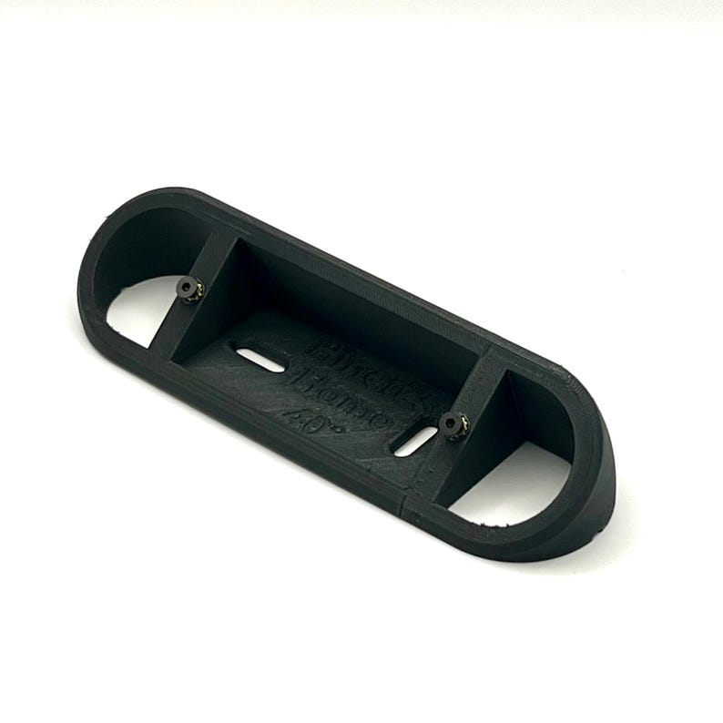 May include: A black plastic 3D printed wall mount with two screw holes and the text "Printed by MakerBot 40%".