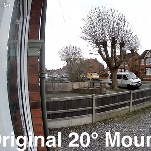 May include: A wide-angle view of a residential street with a white van parked in front of a brick house. The image is taken from a doorbell camera mounted on a house with a white door and a wooden fence. The text "Original 20&deg; Mount" is visible at the bottom of the image.