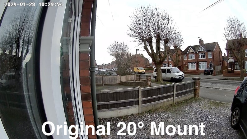 May include: A wide-angle view of a residential street with a white van parked in front of a brick house. The image is taken from a doorbell camera mounted on a house with a white door and a wooden fence. The text "Original 20&deg; Mount" is visible at the bottom of the image.