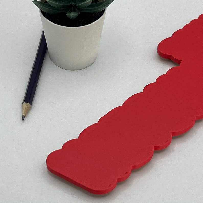 May include: A bright red, scalloped edge, decorative piece made of foam board.