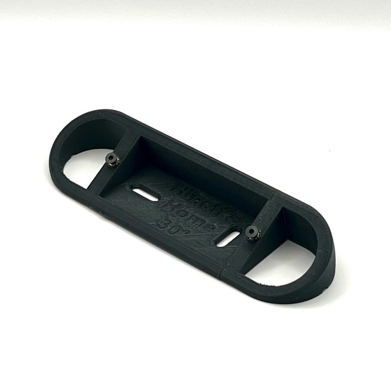 May include: Black plastic 3D printed part with two holes and the text "WARNING HOT SURFACE 30C" printed on the surface.
