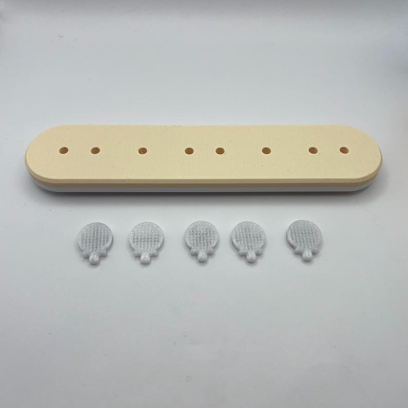 May include: A white rectangular tray with eight holes and five white round silicone stoppers.