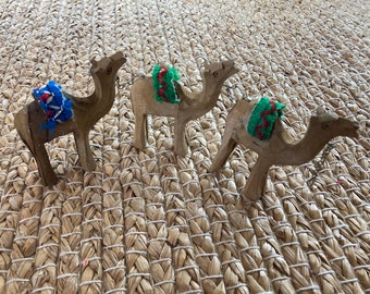 Three Hand Carved Wood Camels with Cloth Seats and Attached Chain