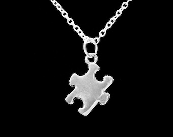 May include: A silver chain necklace with a silver puzzle piece pendant.