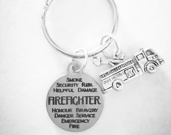 May include: Silver keychain with a round charm that says "SMOKE SECURITY RISK HELPFUL DAMAGE FIREFIGHTER HONOUR BRAVERY DANGER SERVICE EMERGENCY FIRE" and a small silver charm of a fire truck with the words "OUR HEROES" and "F.D."