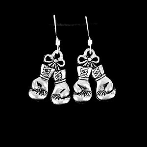 May include: A pair of silver earrings featuring a pair of boxing gloves with a bow on top.