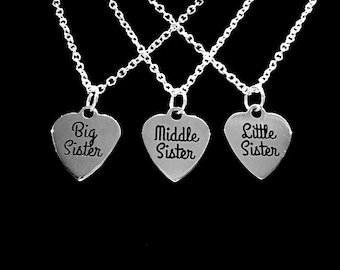 May include: Three silver necklaces with heart-shaped pendants. The pendants say "Big Sister", "Middle Sister", and "Little Sister".
