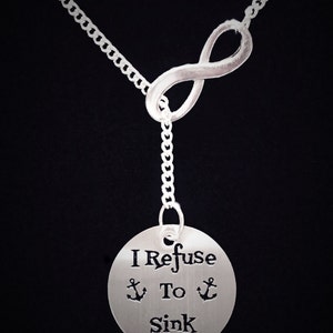 May include: Silver necklace with an infinity symbol charm and a round pendant that says "I Refuse To Sink" with two anchor symbols.