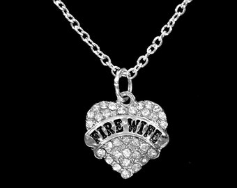 May include: Silver necklace with a heart-shaped pendant that says "FIRE WIFE" in black lettering and is covered in clear rhinestones.