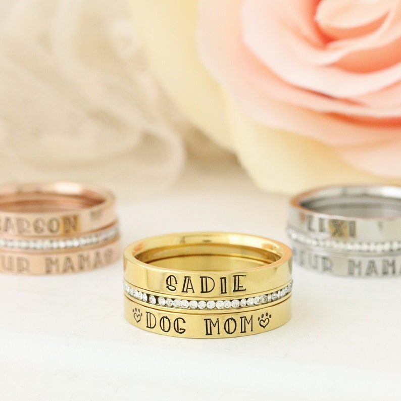 Puede incluir: Conjunto de anillos apilables de acero inoxidable dorado con una banda de diamantes y texto grabado que dice "Sadie Dog Mom".