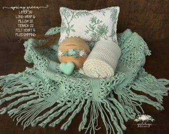 May include: A newborn photography prop set in spring green. The set includes a fringed blanket, a floral pillow, a wrapped blanket, a felt heart, and a head tieback. The set is designed for newborn photoshoots.
