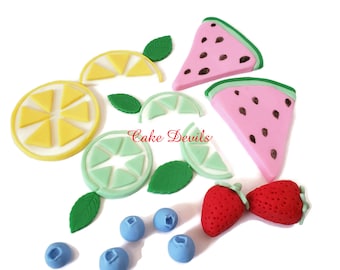 May include: A set of edible cake decorations featuring watermelon, lemon, lime, strawberries, and blueberries. The decorations are made of fondant and are perfect for adding a touch of summer to your next cake.
