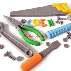 May include: A set of gray, blue, green, orange, and yellow tools, including a wrench, pliers, saw, hammer, and screwdriver, with screws and nuts. The tools spell out the name "COEN".