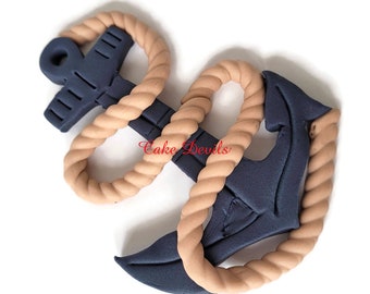 May include: A blue anchor with a brown rope wrapped around it. The anchor is a cake topper and is made of fondant.