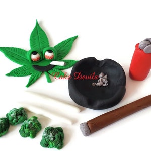 May include: A green marijuana leaf with a smiling face, holding a cigarette, a black ashtray with gray ash, a brown cigar, and a red lighter.  The text "Cake Devils" is visible in the image.