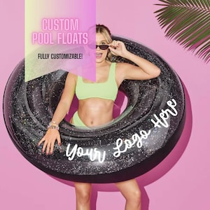 May include: Black glitter-covered inflatable pool float with the text "Your Logo Here". The float is round and has a black interior. The image also includes the text "CUSTOM POOL FLOATS" and "FULLY CUSTOMIZABLE!"
