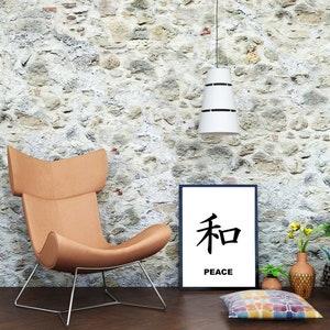 May include: A brown leather armchair with a metal frame sits in front of a stone wall. A black framed print with the Japanese character for peace and the word "peace" below it hangs on the wall. There are potted plants and a colorful throw pillow on the floor.