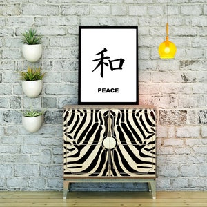 May include: A black and white zebra print cabinet with a black frame and gold accents. A black framed print with the Japanese character for peace and the word "peace" underneath is hanging on a white brick wall above the cabinet. There are three white hanging planters with green plants on the wall to the left of the cabinet. A yellow globe pendant light hangs from the ceiling above the cabinet.