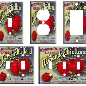 May include: Six vintage-style light switch covers featuring a colorful illustration of apples and the text "Wenatchee Valley Apples Alexander Kielland Brand."