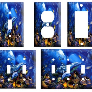 May include: Set of four light switch and outlet covers featuring an underwater scene with a school of colorful fish, coral, and a dolphin swimming through a blue ocean. The covers are available in single, double, and triple switch and outlet configurations.