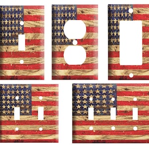 May include: Set of four light switch and outlet covers featuring a distressed American flag design. The covers are in various sizes and configurations, including single switch, double switch, and outlet.