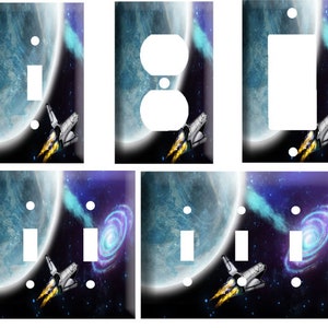May include: A set of six light switch and outlet covers featuring a space-themed design with a blue planet, stars, and a spaceship. The covers are available in single, double, and triple switch configurations.