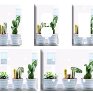 May include: Set of six white light switch covers with a cactus design. Each cover features a different arrangement of cacti in white pots against a white background.