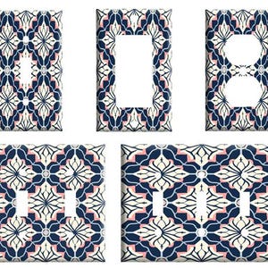 May include: Decorative light switch covers with a floral pattern in navy blue, cream, and blush pink. The set includes covers for a single switch, a double switch, a single outlet, a double outlet, and a rocker switch.