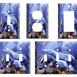 May include: Set of four light switch and outlet covers featuring a colorful underwater scene with dolphins, fish, and coral. The covers are available in single, double, and triple switch configurations.