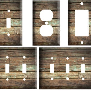 May include: Set of four light switch and outlet covers featuring a rustic woodgrain design with a distressed, weathered look. The covers are in various sizes, including single switch, double switch, and outlet.