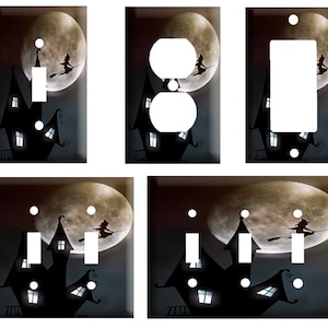 May include: Set of four Halloween-themed light switch and outlet covers featuring a black silhouette of a haunted house with glowing windows against a dark background with a full moon and a witch flying on a broomstick.