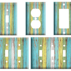 May include: Set of six light switch and outlet covers featuring a distressed wood plank design in shades of blue, green, yellow, and white.