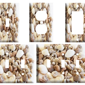 May include: A set of five light switch and outlet covers featuring a close-up image of a variety of seashells in shades of white, brown, and beige.
